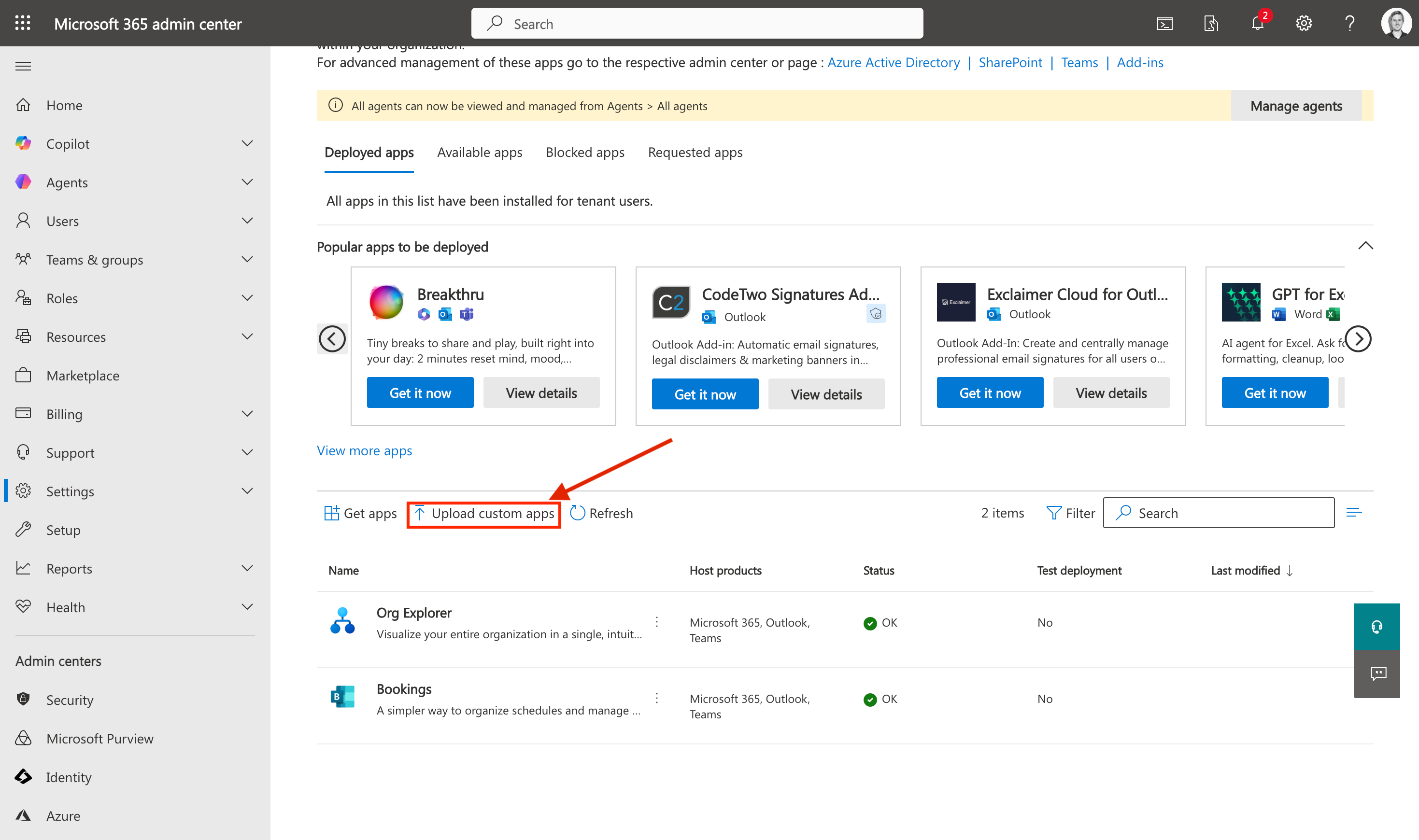Microsoft 365 Admin Center showing the Integrated Apps page with the Upload custom apps button highlighted